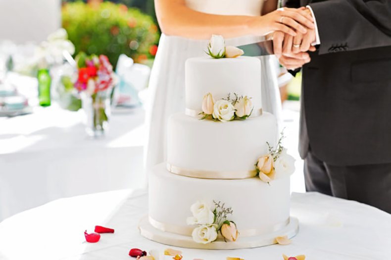 Newlywed Couple Cutting Cake During Reception