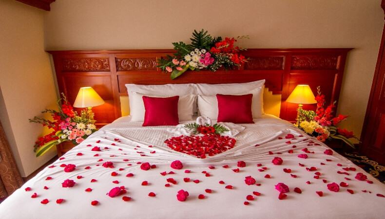 Romantic Bedroom Interior, Kissing Swan Origami Towels and sprinkled fresh  Pink White Rose Flower Petals decoration on bed for newlywed couple. Weddin  Stock Photo - Alamy