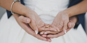Young Couple Holding Wedding Rings on Hands