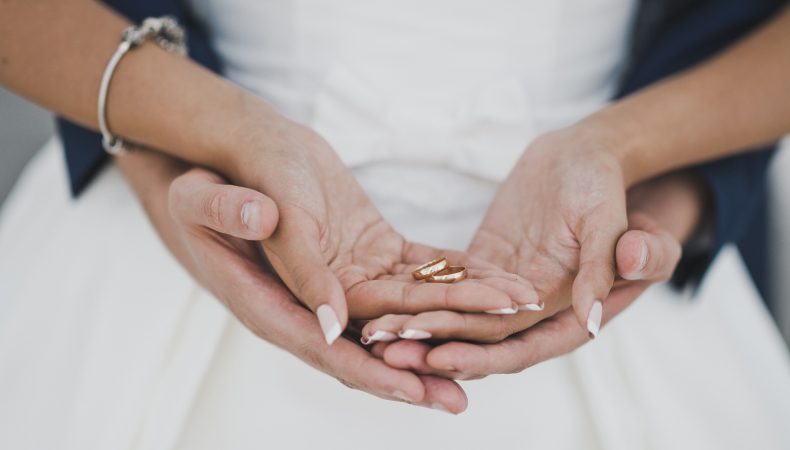 Young Couple Holding Wedding Rings on Hands