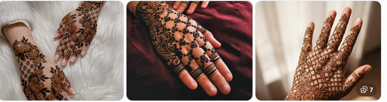 Two hands with elaborate henna designs resting on white fur surface on a light background, close‑up detail of mehndi artistry.