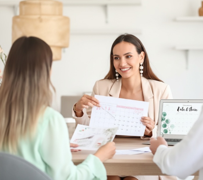 A wedding professional discusses options with a couple to determine their total wedding venue cost.