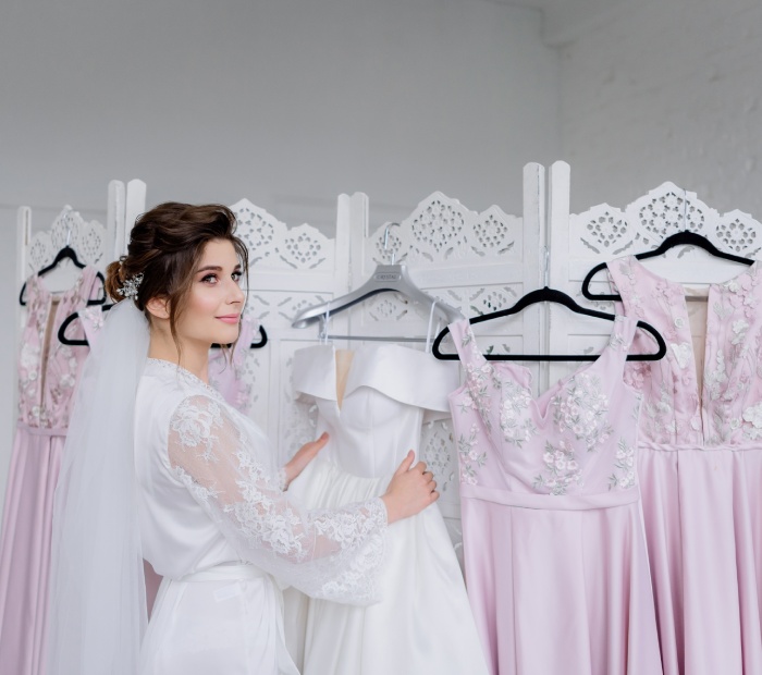 Bride choosing a white wedding dress in a bridal boutique.