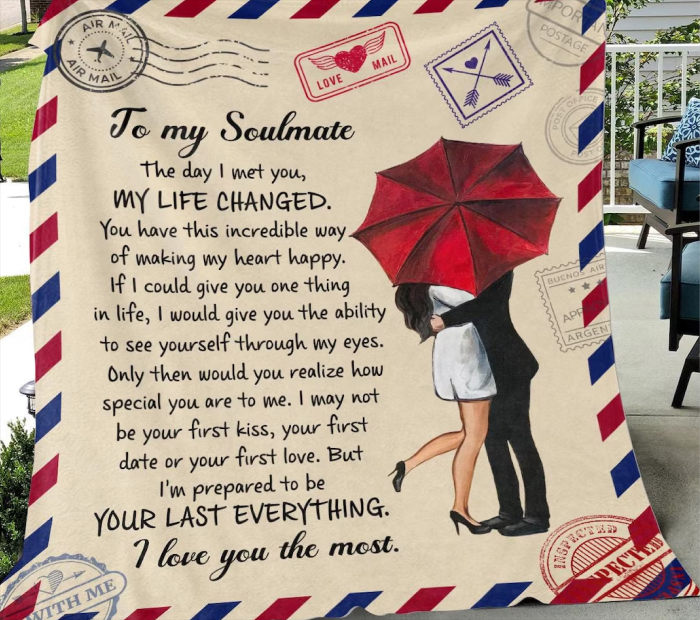 Woman holding a large romantic “To my soulmate” blanket featuring a love letter design with a couple kissing under a red umbrella and vintage airmail border.