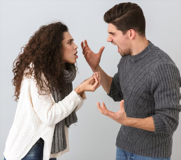 A man and woman arguing face-to-face, shouting and gesturing angrily during a relationship conflict.
