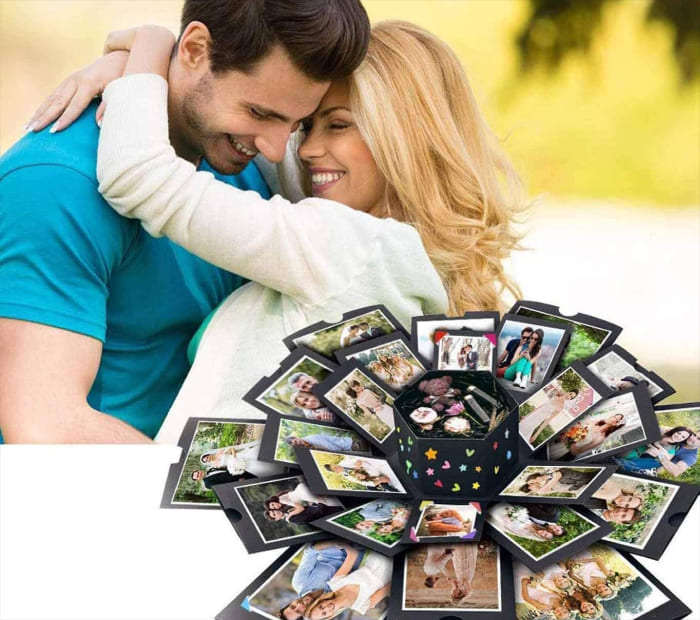 A couple hugging behind an open multi-layered photo box.