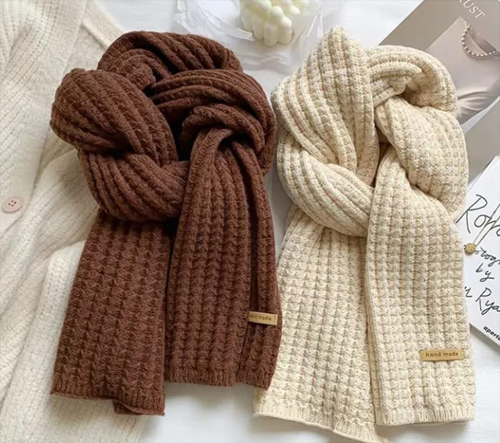 Knit Scarves: Brown and cream knitted scarves on a white surface.
