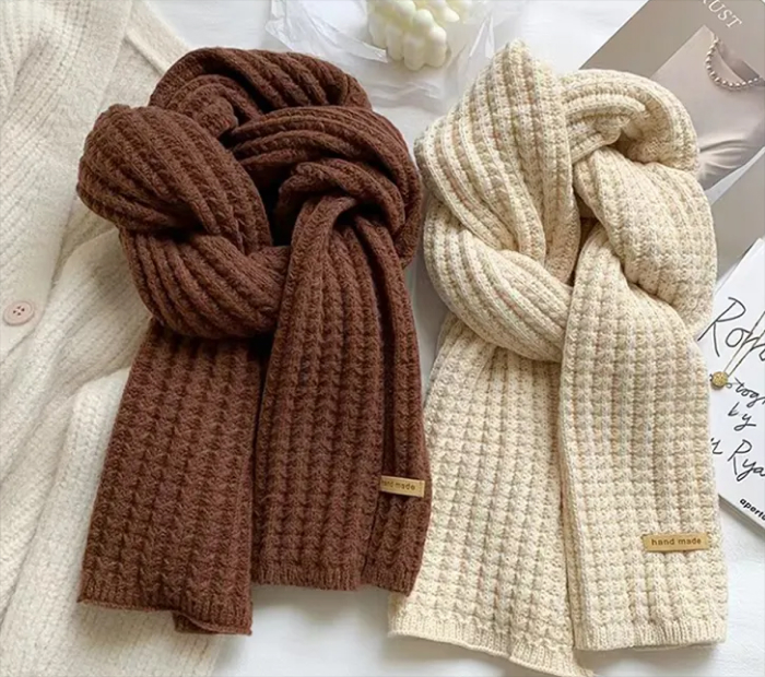 Knit Scarves: Brown and cream knitted scarves on a white surface.