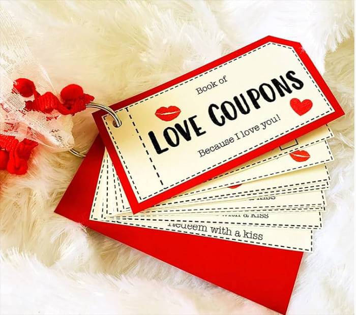 Love coupon book with red and white Valentine-themed tags on a soft white background, symbolizing a thoughtful and romantic gift idea for Valentine’s Day.