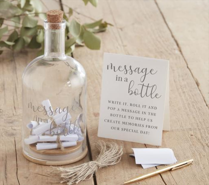 Decorative “Message in a Bottle” Valentine’s gift with small rolled notes inside a glass bottle, displayed with a card and pen on a wooden table.