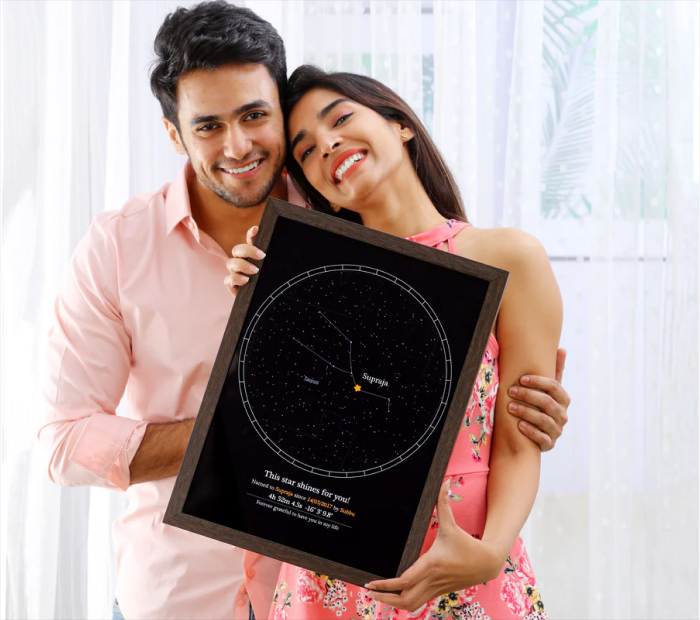 Smiling couple holding a framed personalized star map print with a night sky design, shown as a romantic Valentine’s Day gift.