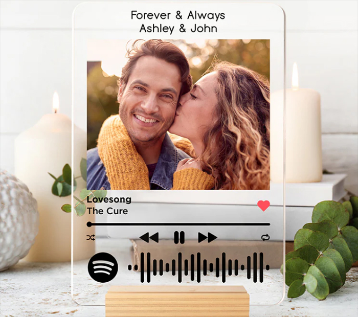 Personalized Spotify-style acrylic plaque showing a couple photo, song details, playback controls, and a scannable Spotify code.